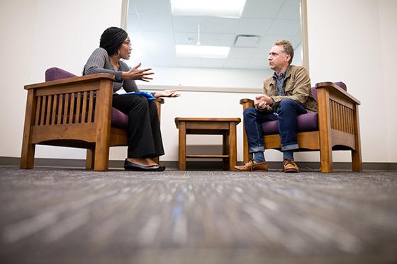 Photo of a Chatham University counseling psychology student counseling a man sitting across from her. 