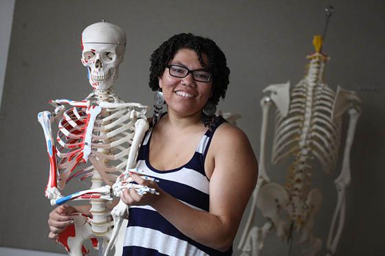 Photo of a Chatham University student posing with a skeleton model