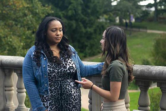 Photo of a student success coach speaking to a student outside on Shadyside Campus