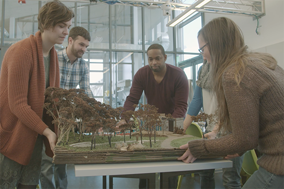 四名波胆网站学生在伊甸园大厅校园的实验室里的照片, 正在做一个森林模型