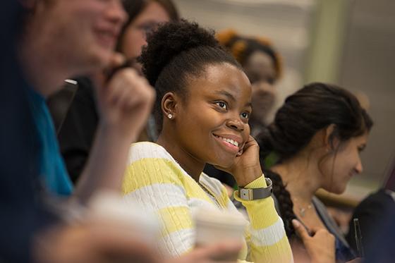 Photo of a female Chatham University student smiling while paying attention during a lecture