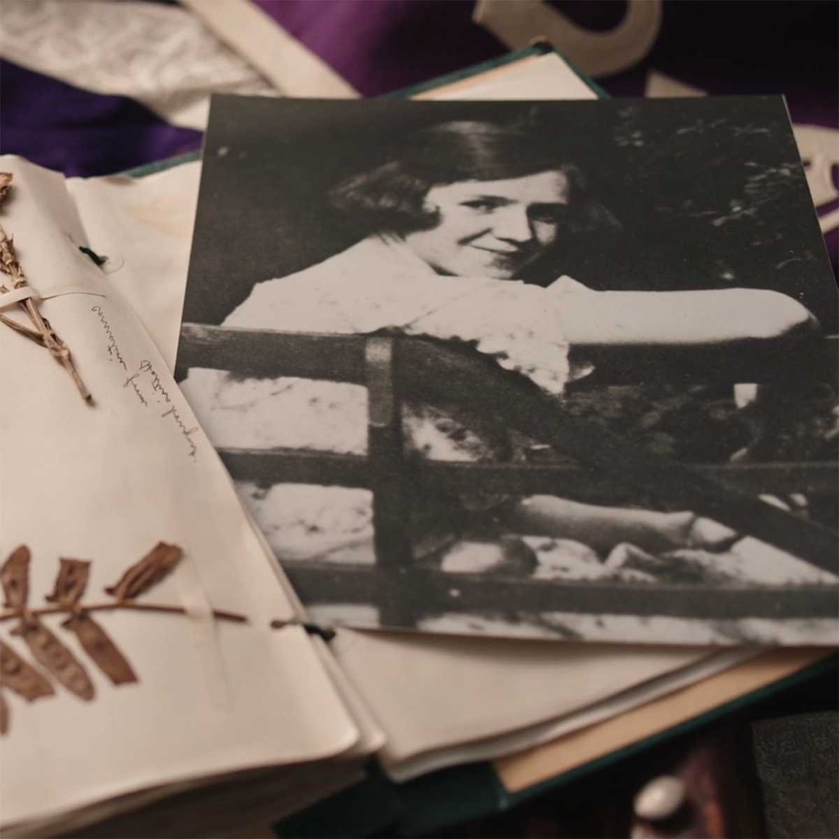 Close-up photo of a scrapbook with dried flowers and a black and white photo clipping of Rachel Carson